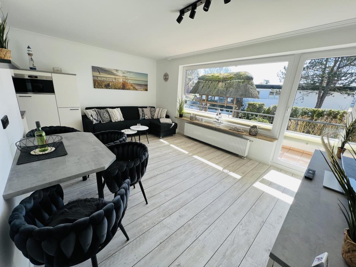 Living and dining area with view of balcony and garden.