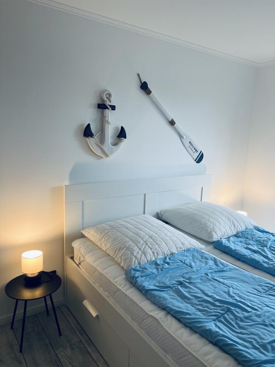 Bedroom with bed, wall decor, and nightstand.