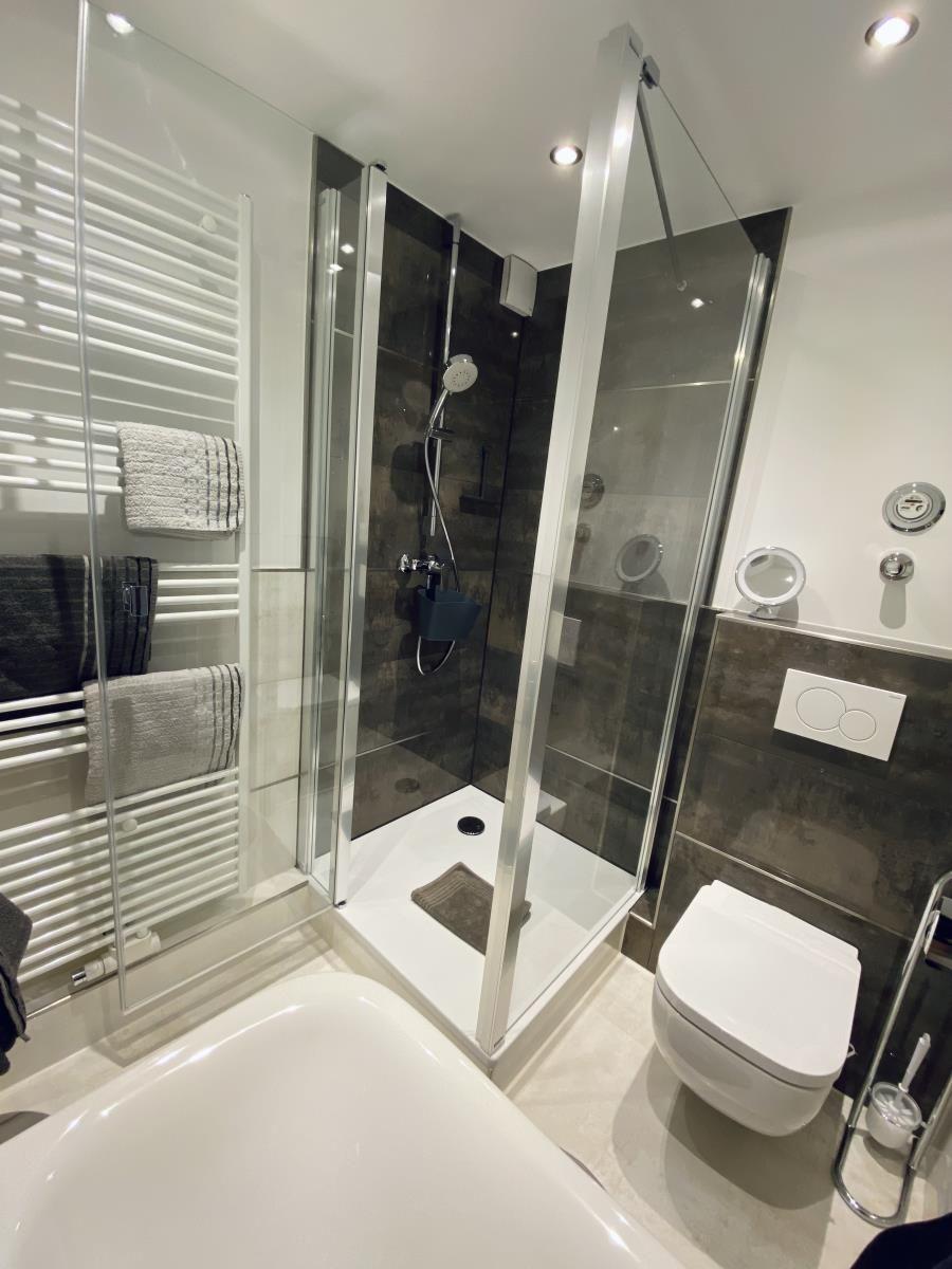 Badezimmer mit Dusche, Toilette und Badewanne.