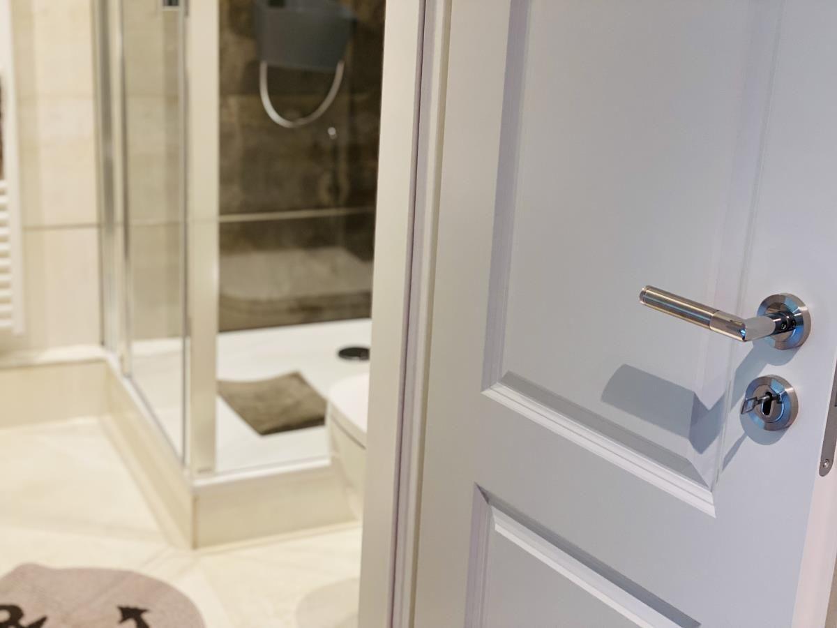 Badezimmer mit Dusche und Toilette hinter Tür
