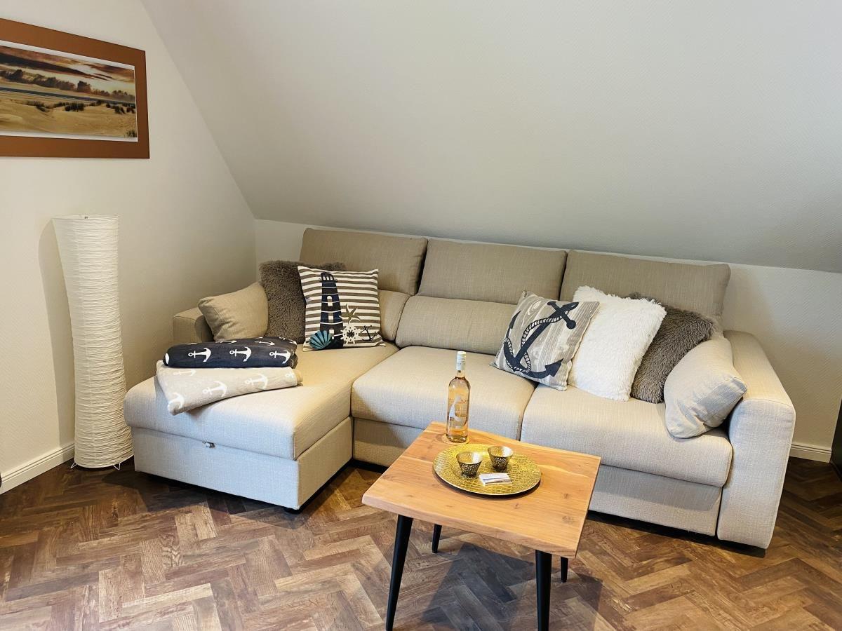 Ein Wohnzimmer mit Ecksofa, Holztisch und Himmelbett.
