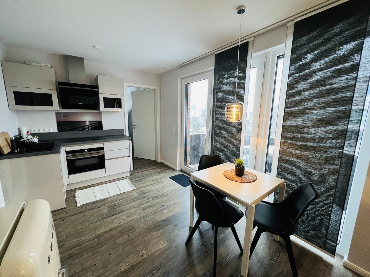 Küche mit Essbereich, Balkon und moderner Einrichtung.