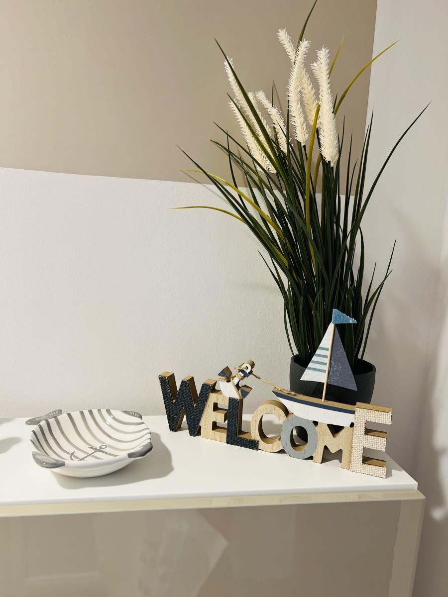 Willkommensdekoration mit Boot und Pflanze auf einem Tisch