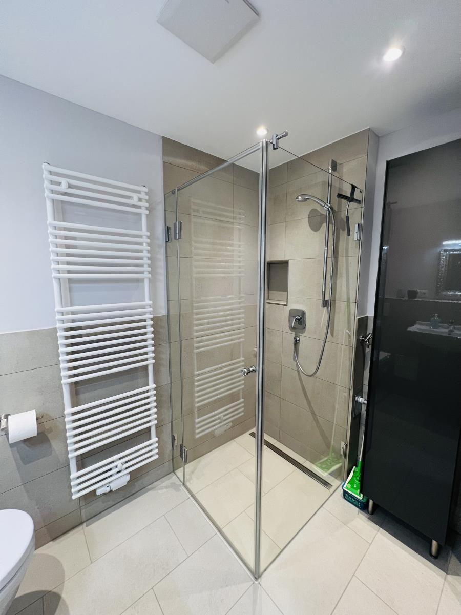 Bad mit Dusche, Heizkörper und Toilette