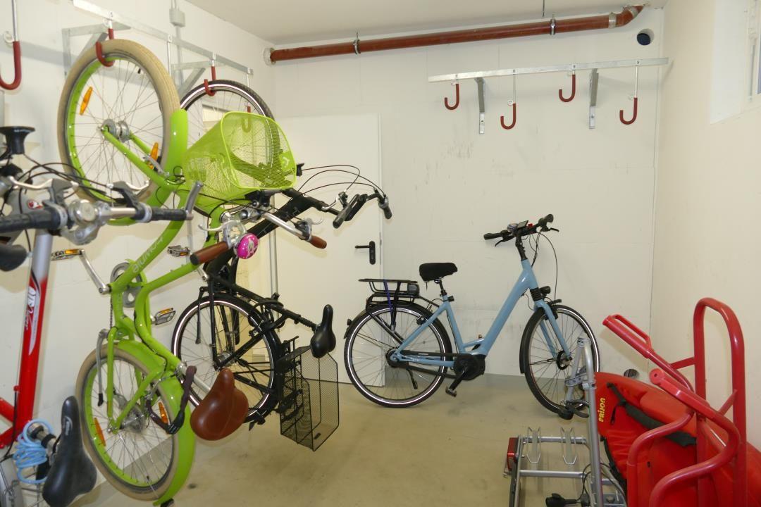 Storage area with multiple bicycles and hooks for outdoor equipment.