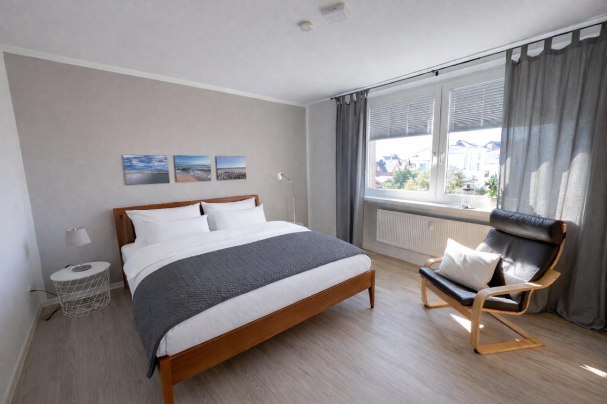 Schlafzimmer mit Doppelbett, Sessel und Fenster mit Blick.