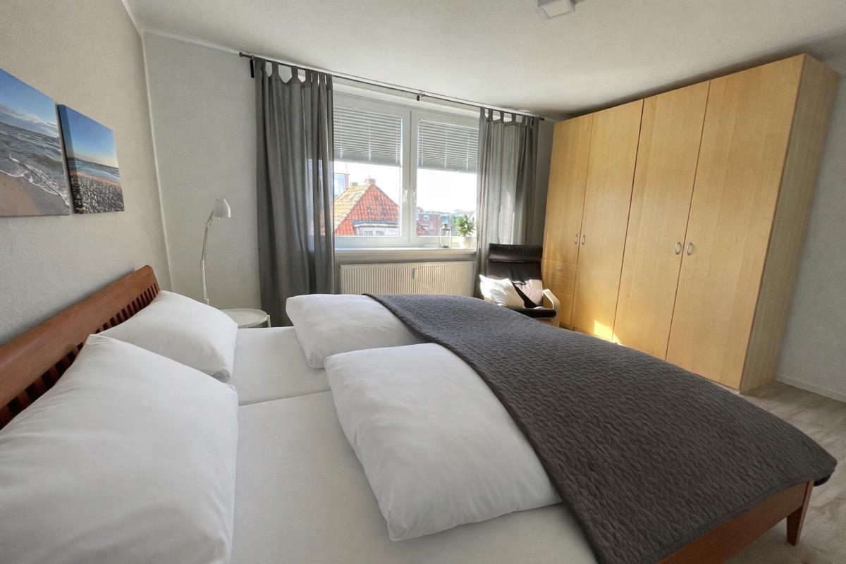 Schlafzimmer mit Doppelbett, Kleiderschrank und Fenster mit Blick.