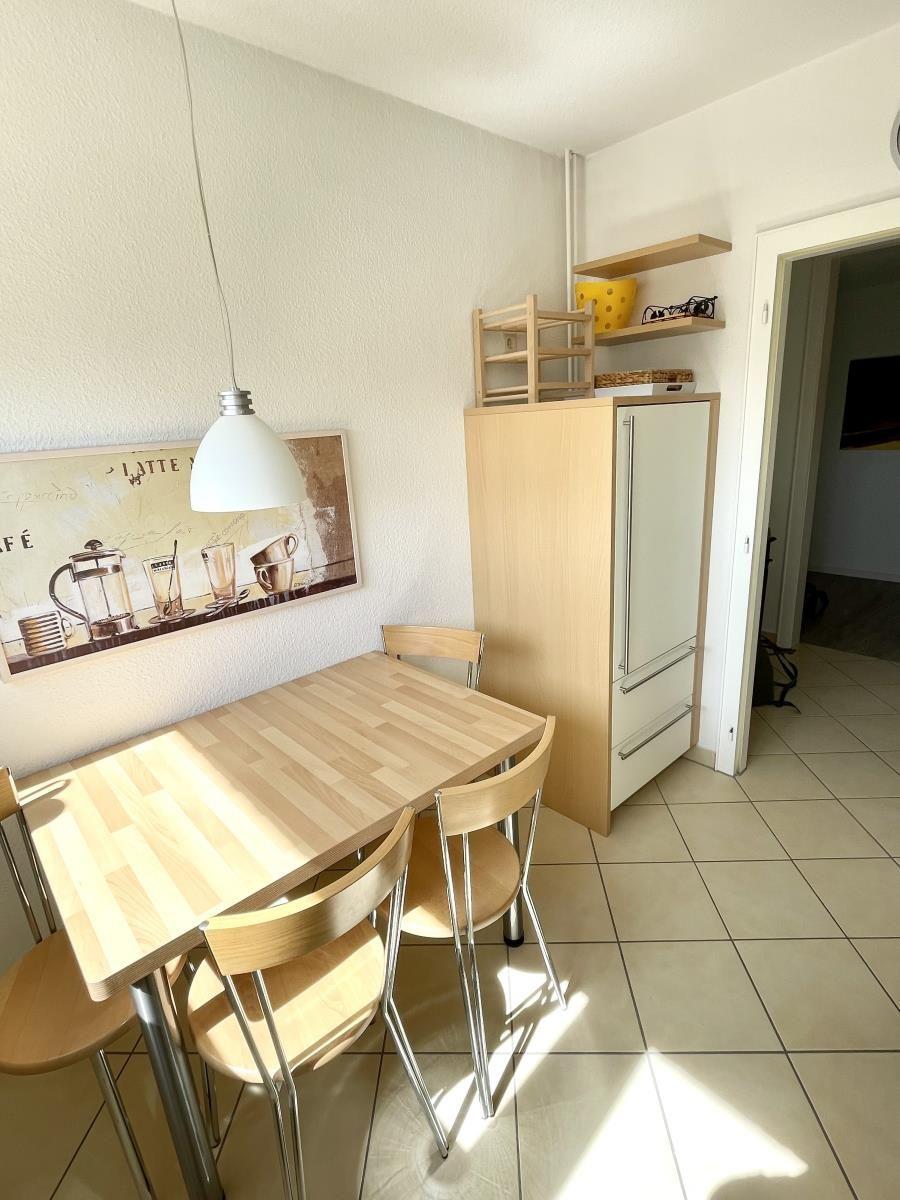 Essbereich mit Tisch, Stühlen und Küchenzeile