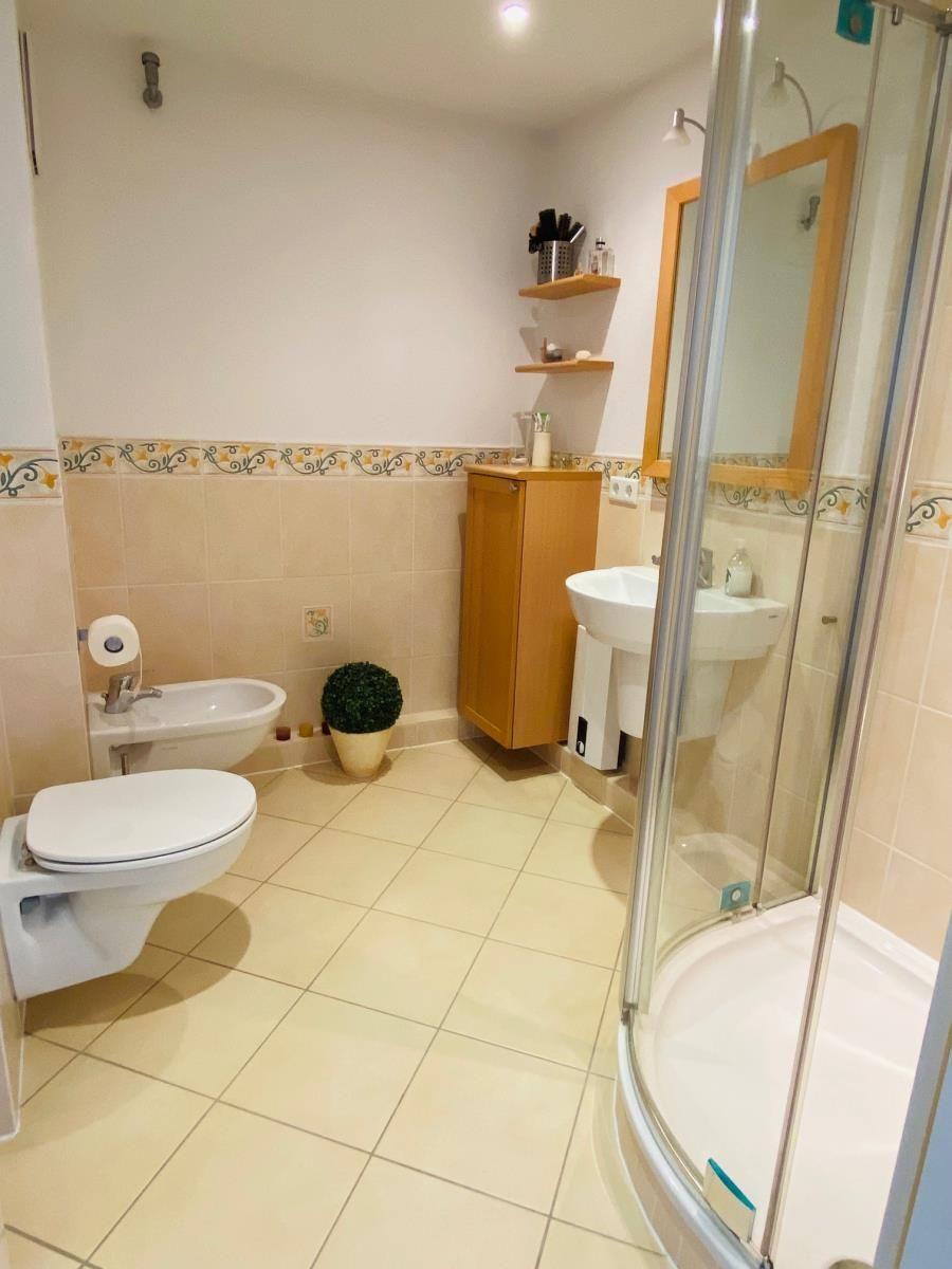Badezimmer mit Dusche, Waschbecken und Toilette.