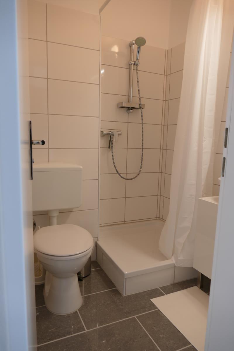 Badezimmer mit Dusche, Toilette und Waschbecken