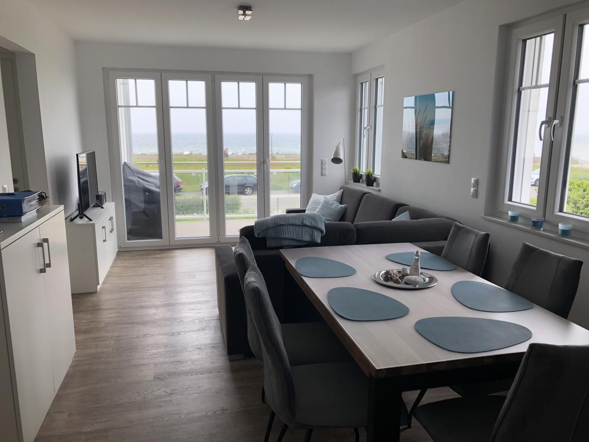 Living and dining area with sea view and modern furnishings.