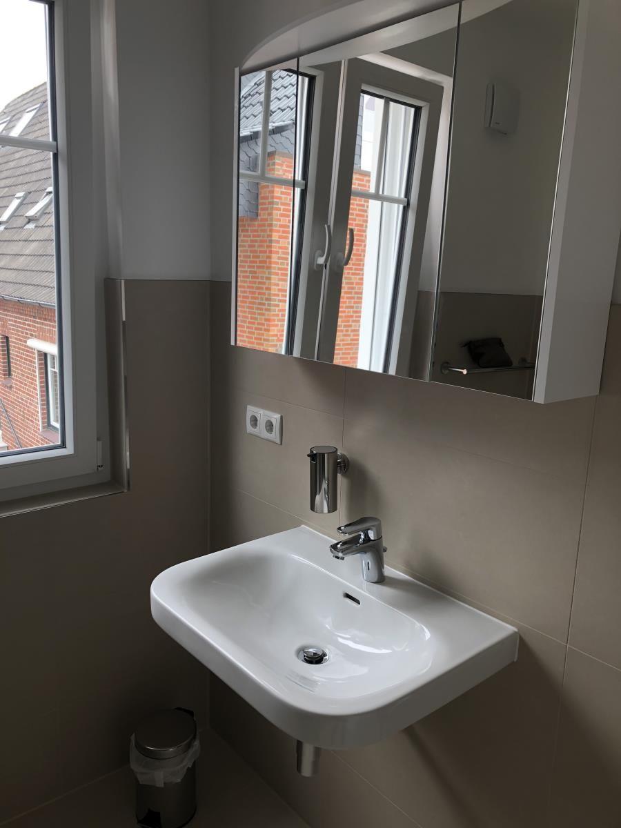 Sink with mirror and window view of buildings