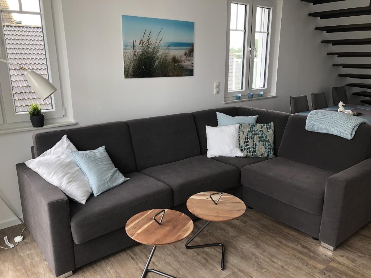 Living room with gray sofa, two round tables, and wall art.