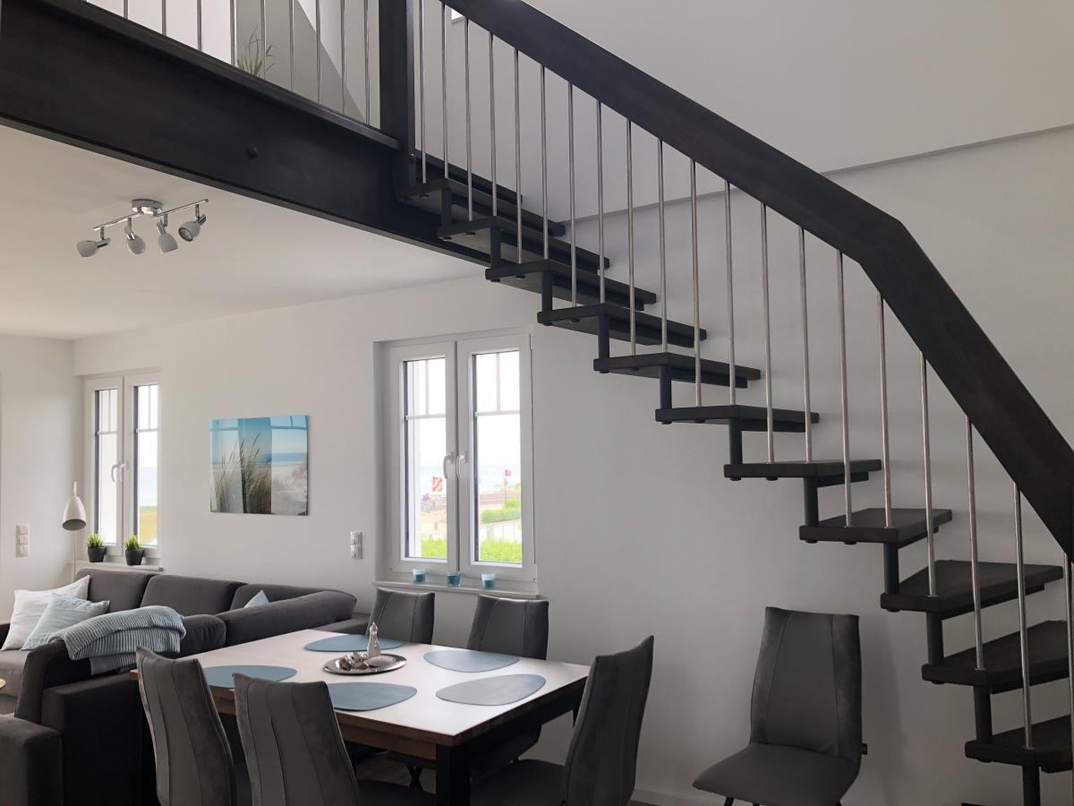Dining area with table and chairs under a staircase.