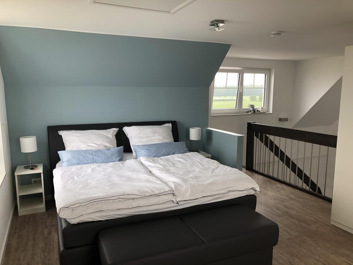 Bedroom with double bed, window, and staircase