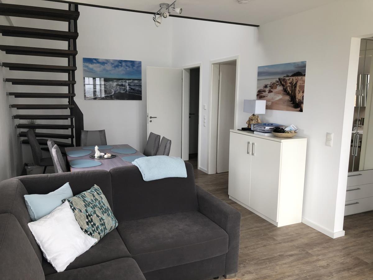 Living and dining area with sofa, table, and wall art.