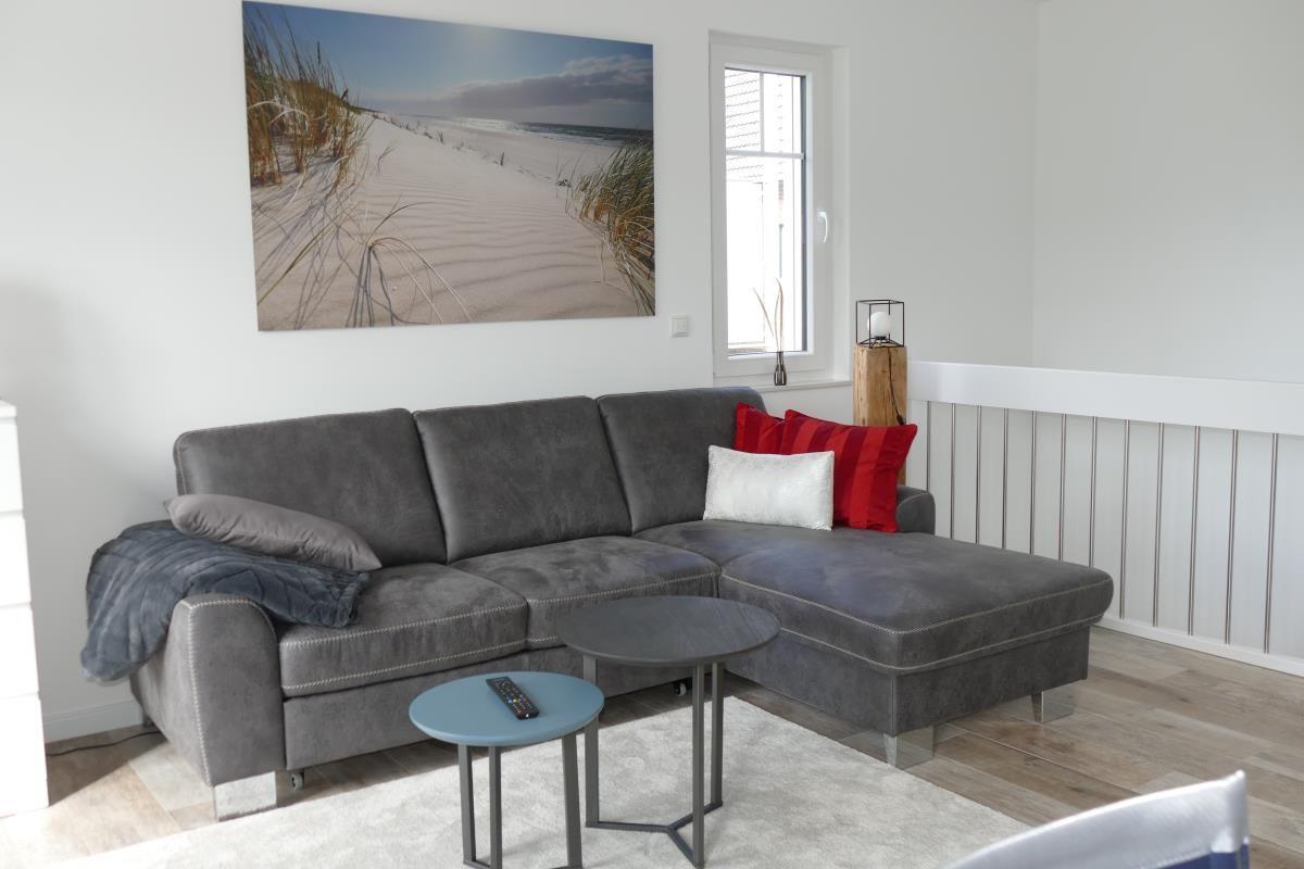 Gray sofa with cushions, table, and wall picture