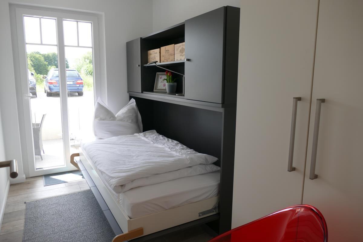 Bedroom with bed, wardrobe, and window to terrace.