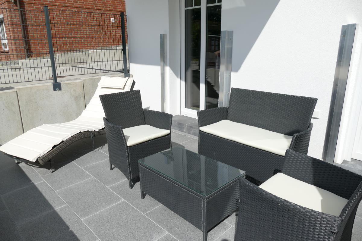 Terrace with garden furniture, bench, chaise lounge, and glass table.