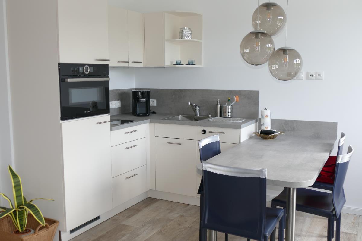 Modern kitchen with dining area and built-in oven.
