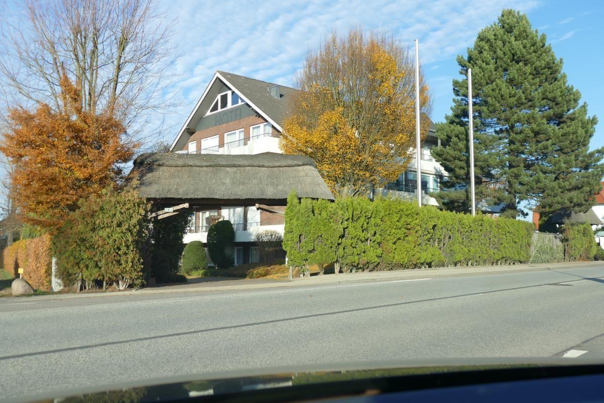 Haus mit Strohdach und Bäumen im Herbst
