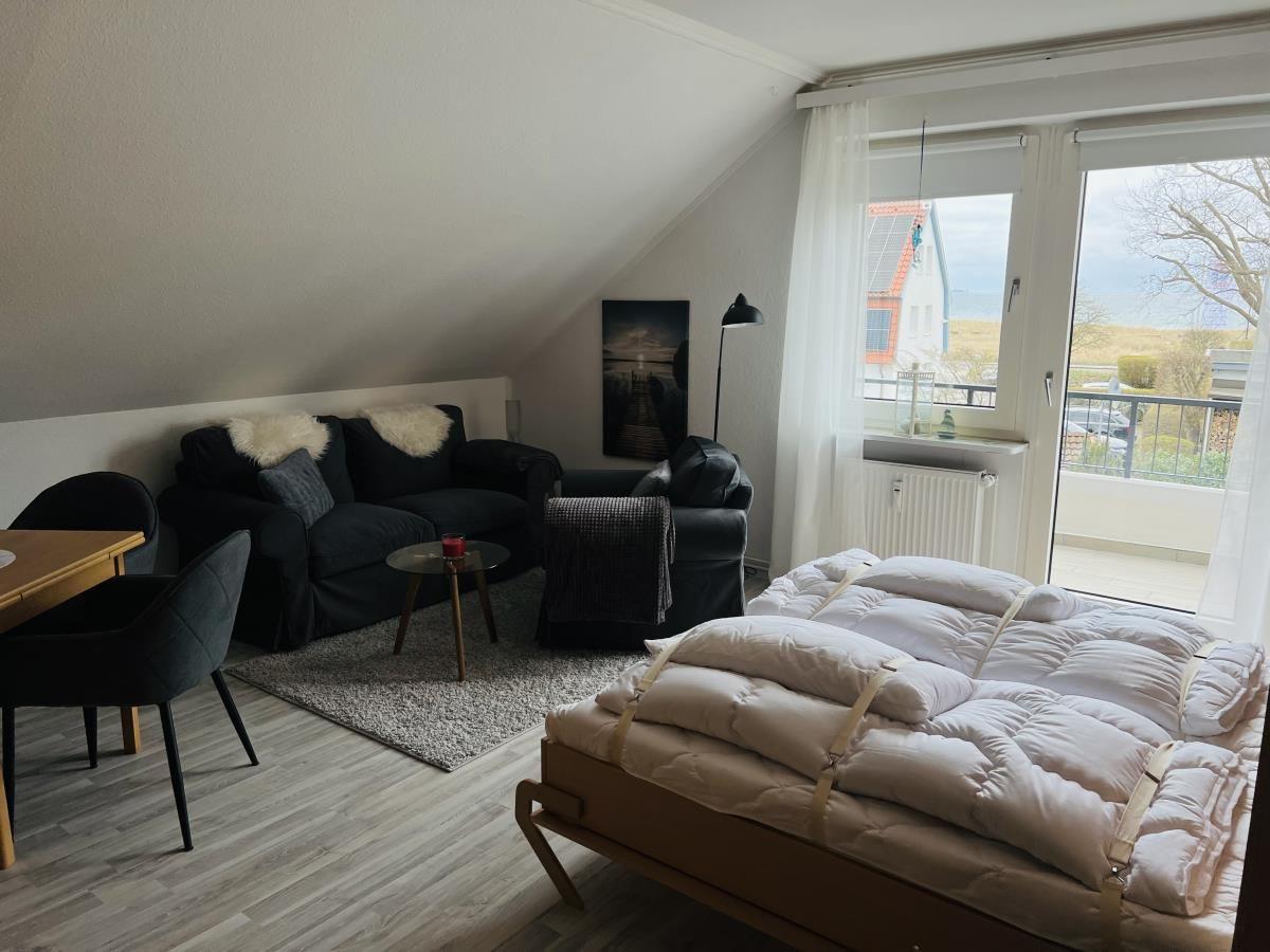 Schlafzimmer mit Schlafcouch, Couch und Balkon. Blick auf das Meer.