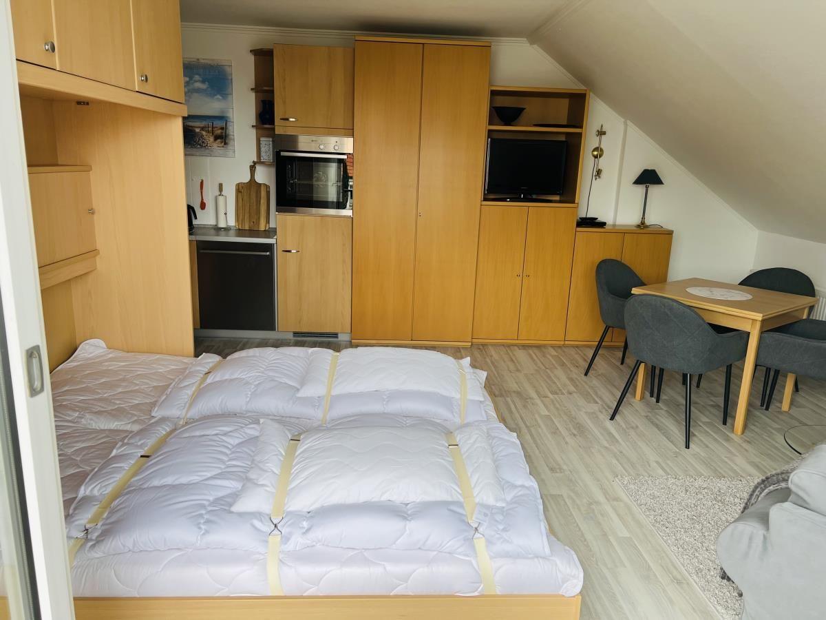 Schlafzimmer mit Bett, Küchenzeile und Esstisch.