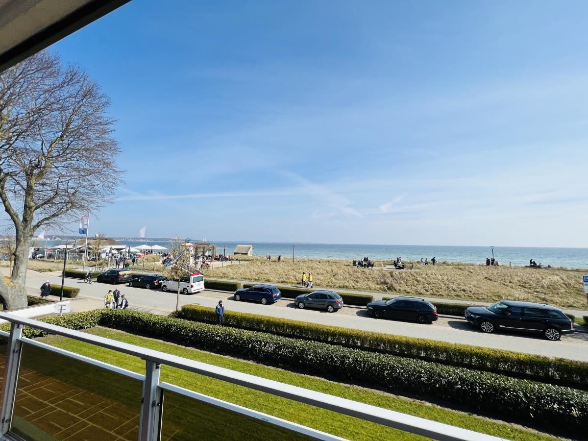 Blick von Balkon auf Strand mit Autos und Meer