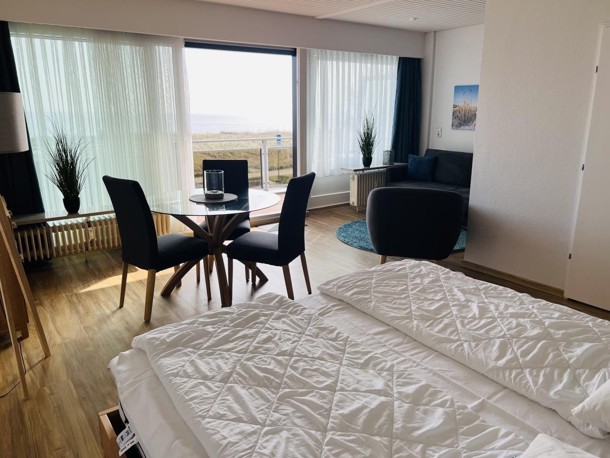Schlafzimmer mit Blick aufs Meer, Esstisch und Sofa