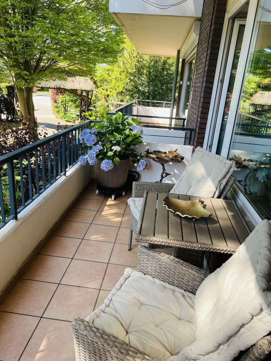 Terrasse mit Sitzgruppe, Pflanzen und Blick auf Garten.