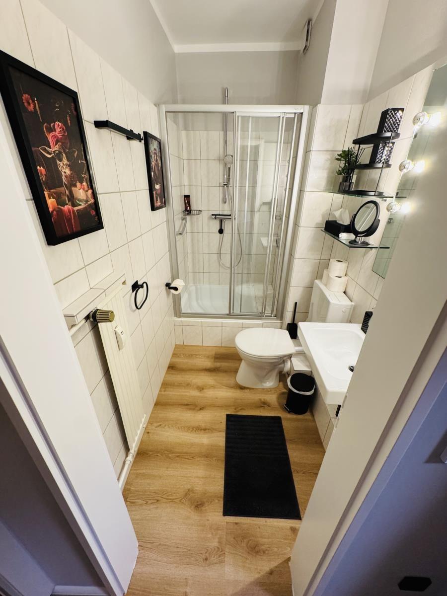 Badezimmer mit Dusche, Toilette und Waschbecken