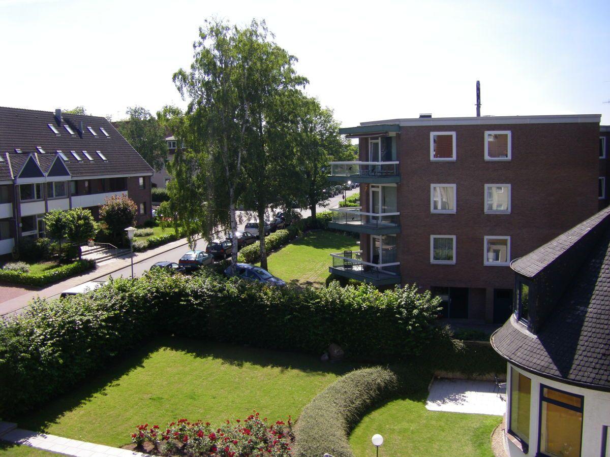 Hochhaus mit Balkonen, Grünfläche und gepflegtem Gartenbereich.