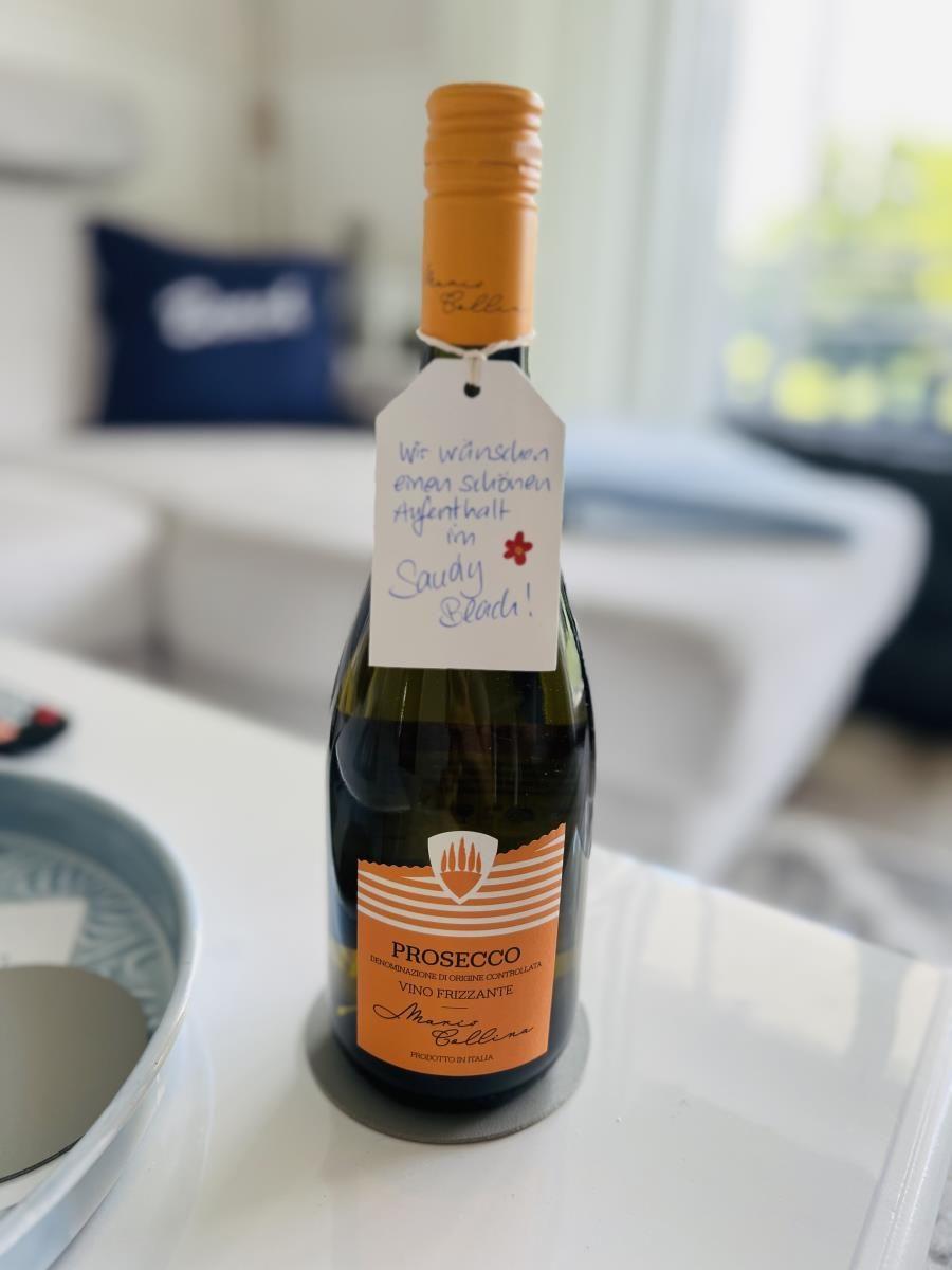Prosecco-Flasche mit persönlichem Gruß für den Aufenthalt in Sandy Beach.