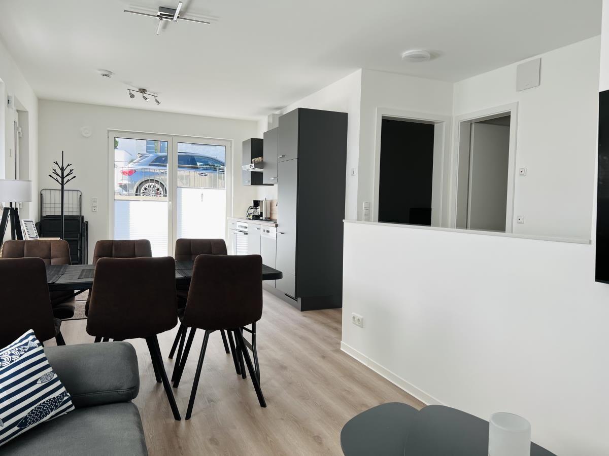 Living and dining area with table, chairs, and kitchenette.