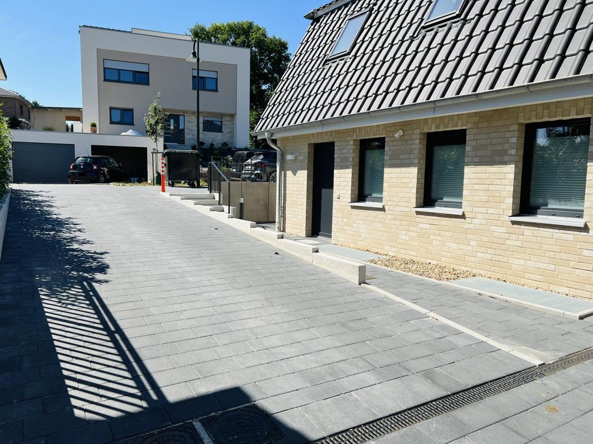 House with stone facade, skylights, and paved driveway.