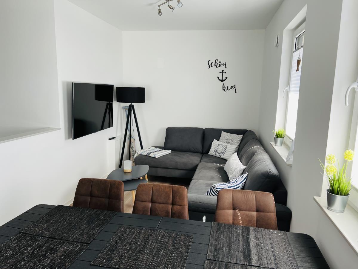 Living and dining area with sofa, TV, and table with chairs.