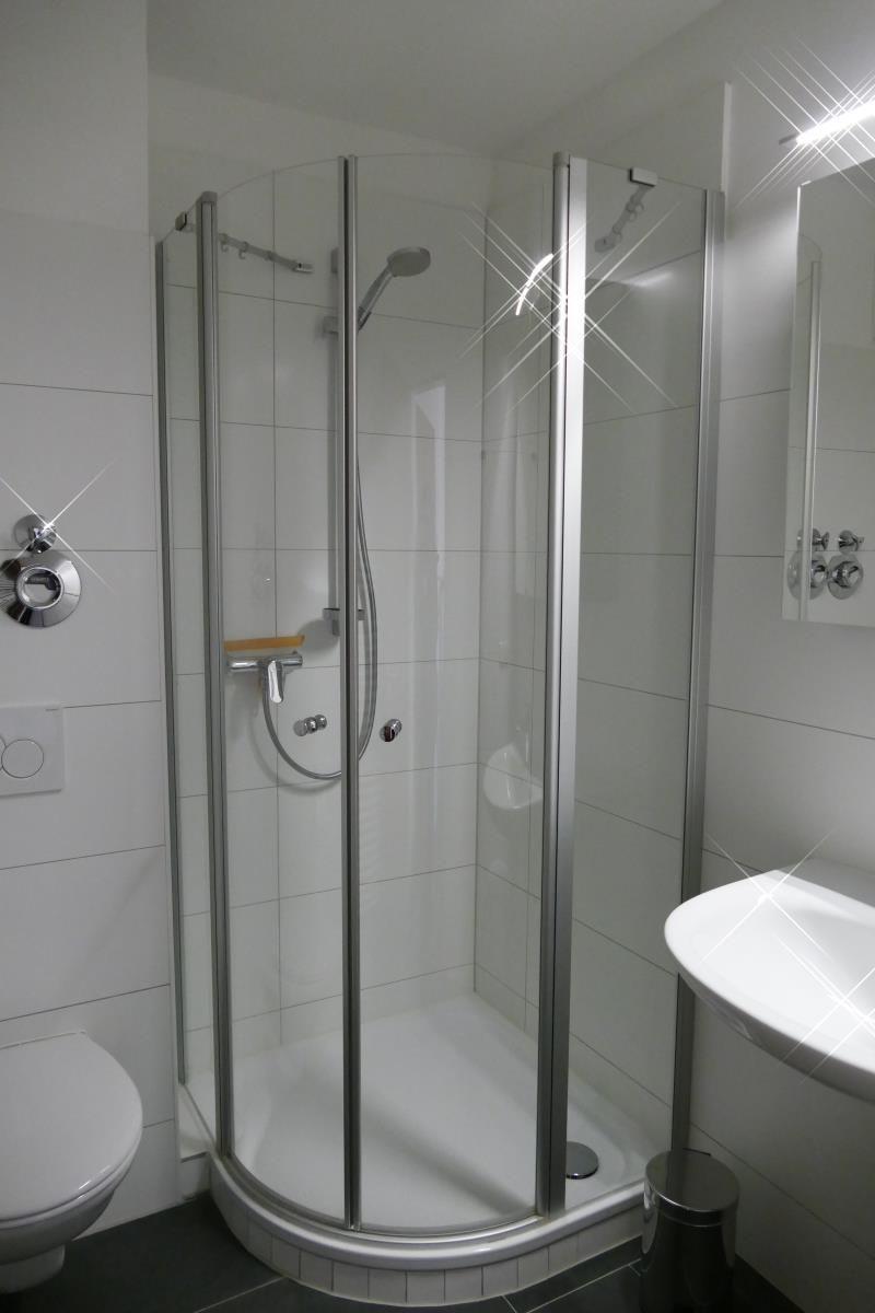 Badezimmer mit Dusche, Waschbecken und Toilette