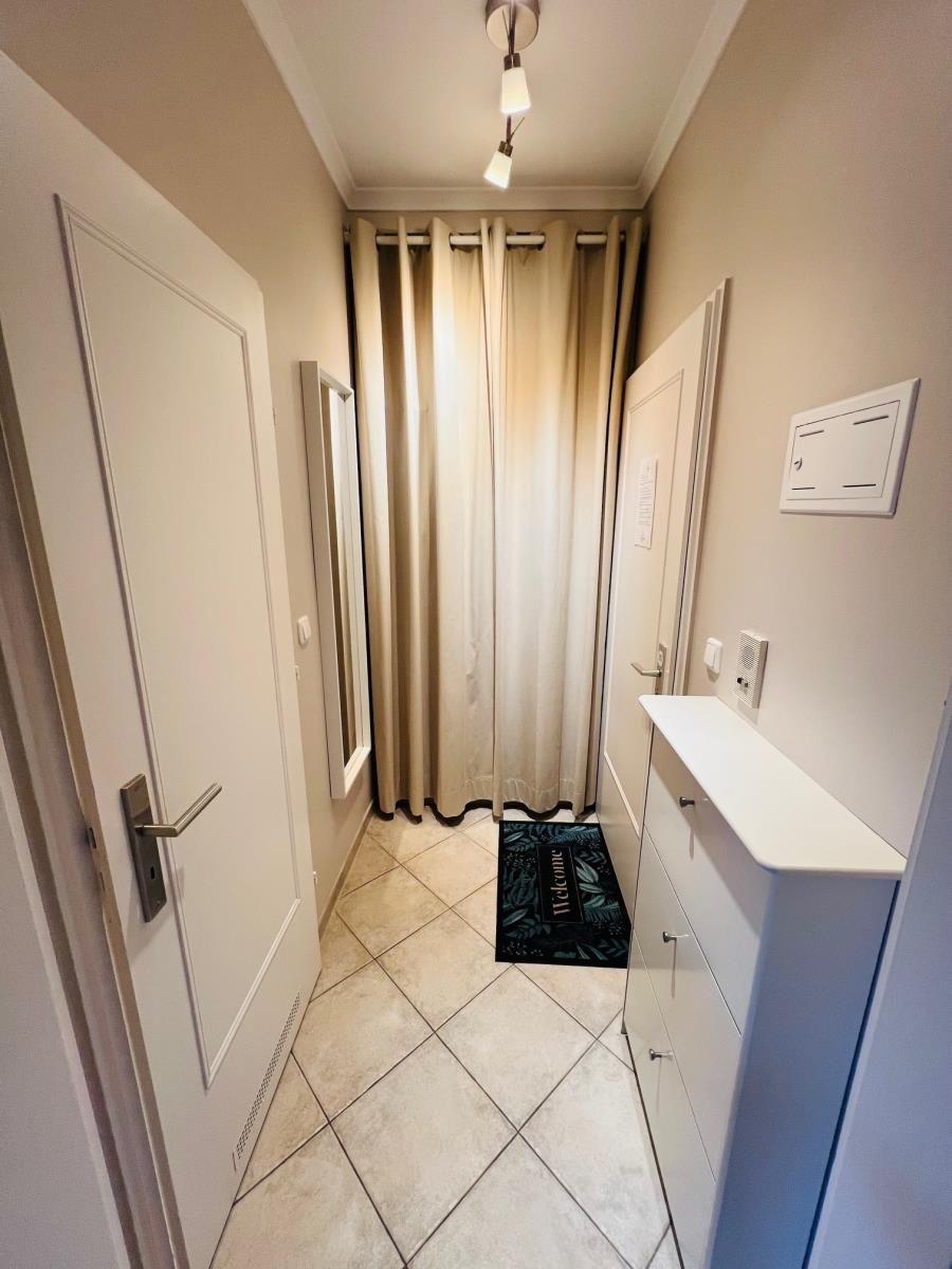 Eingangsbereich mit Tür, Gardine und Schrank.