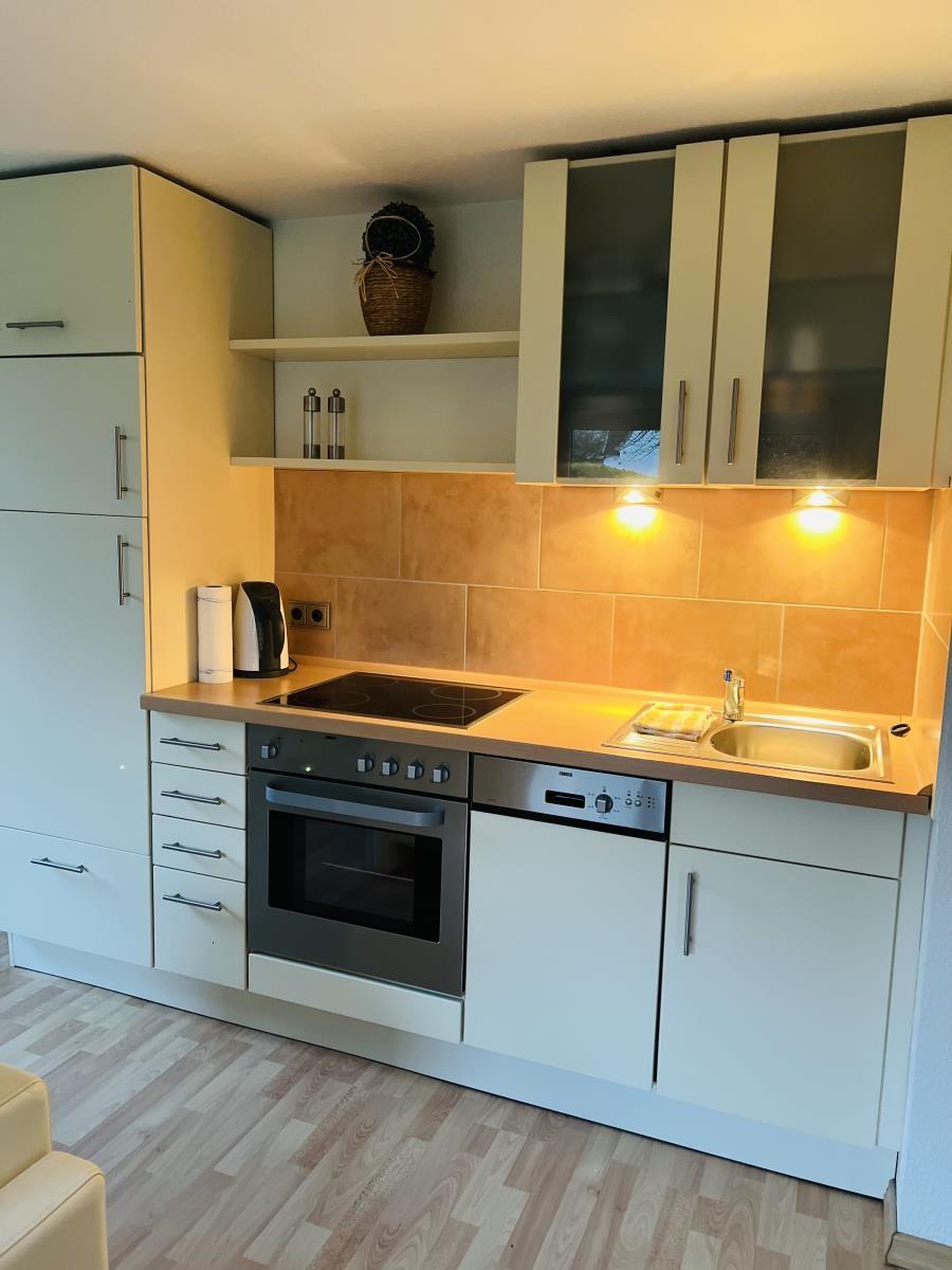 Küche mit Arbeitsplatte, Spüle, Herd und Kühlschrank.