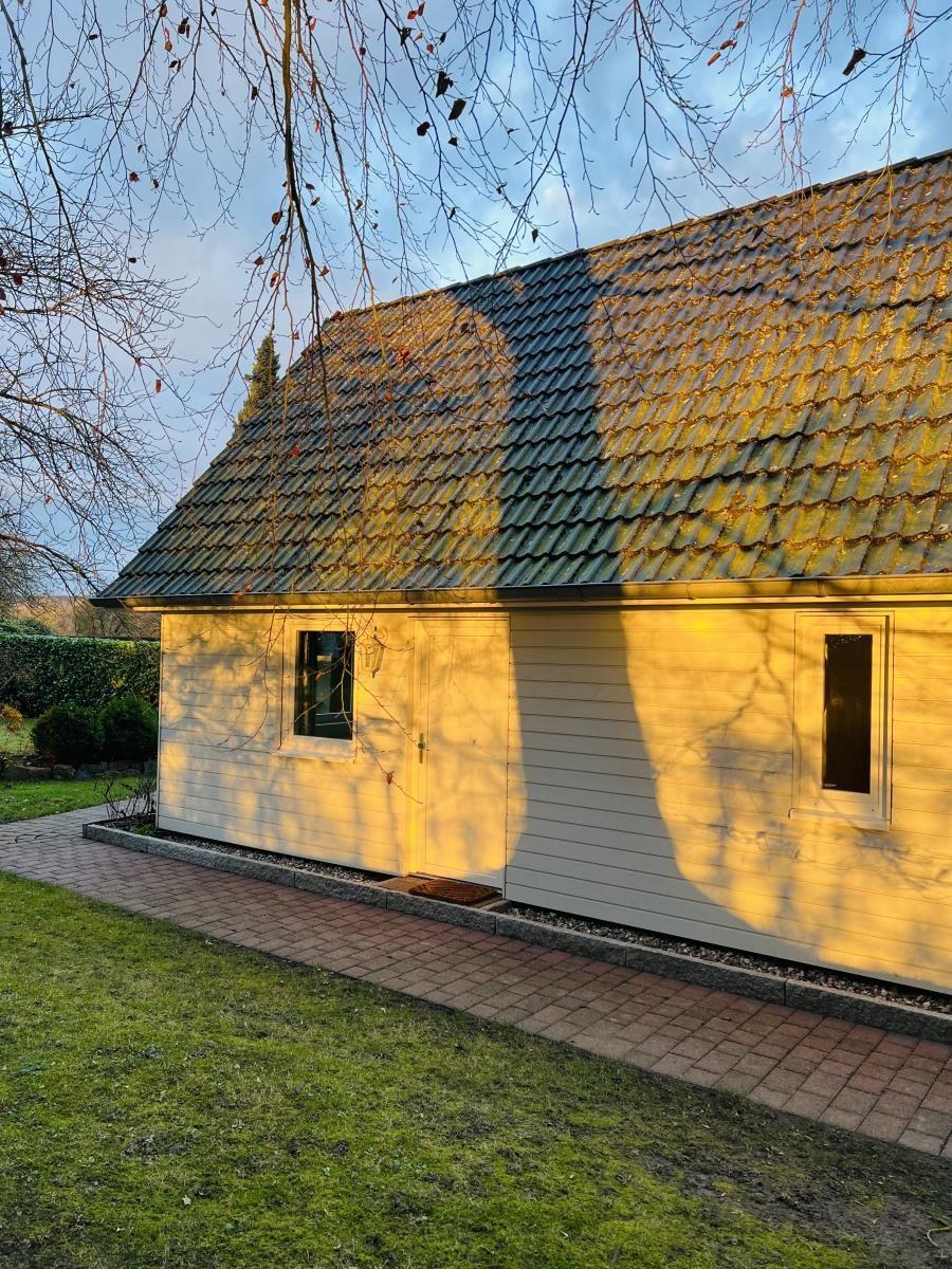 Haus mit Holzfassade, Dach und Terrasse im Garten