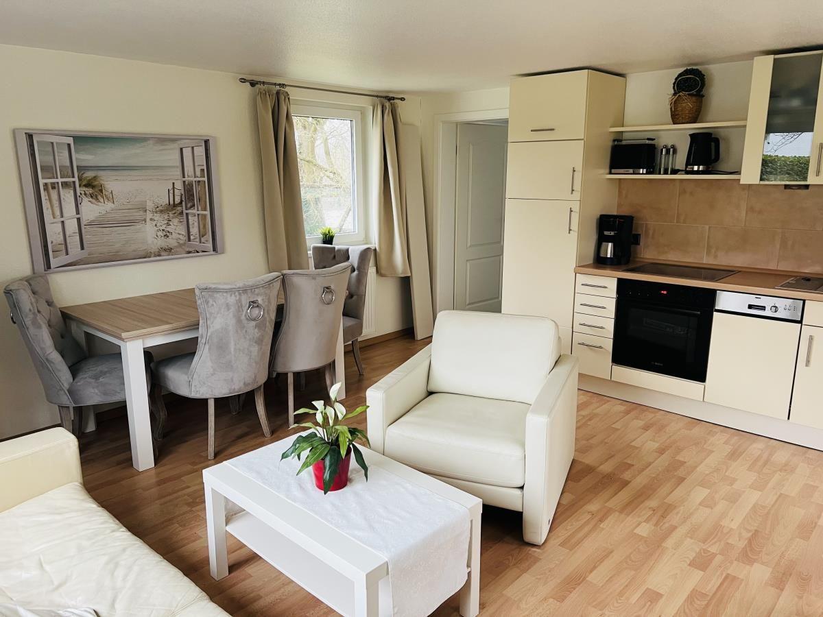 Wohnküche mit Esstisch, Sessel und Kücheneinrichtung