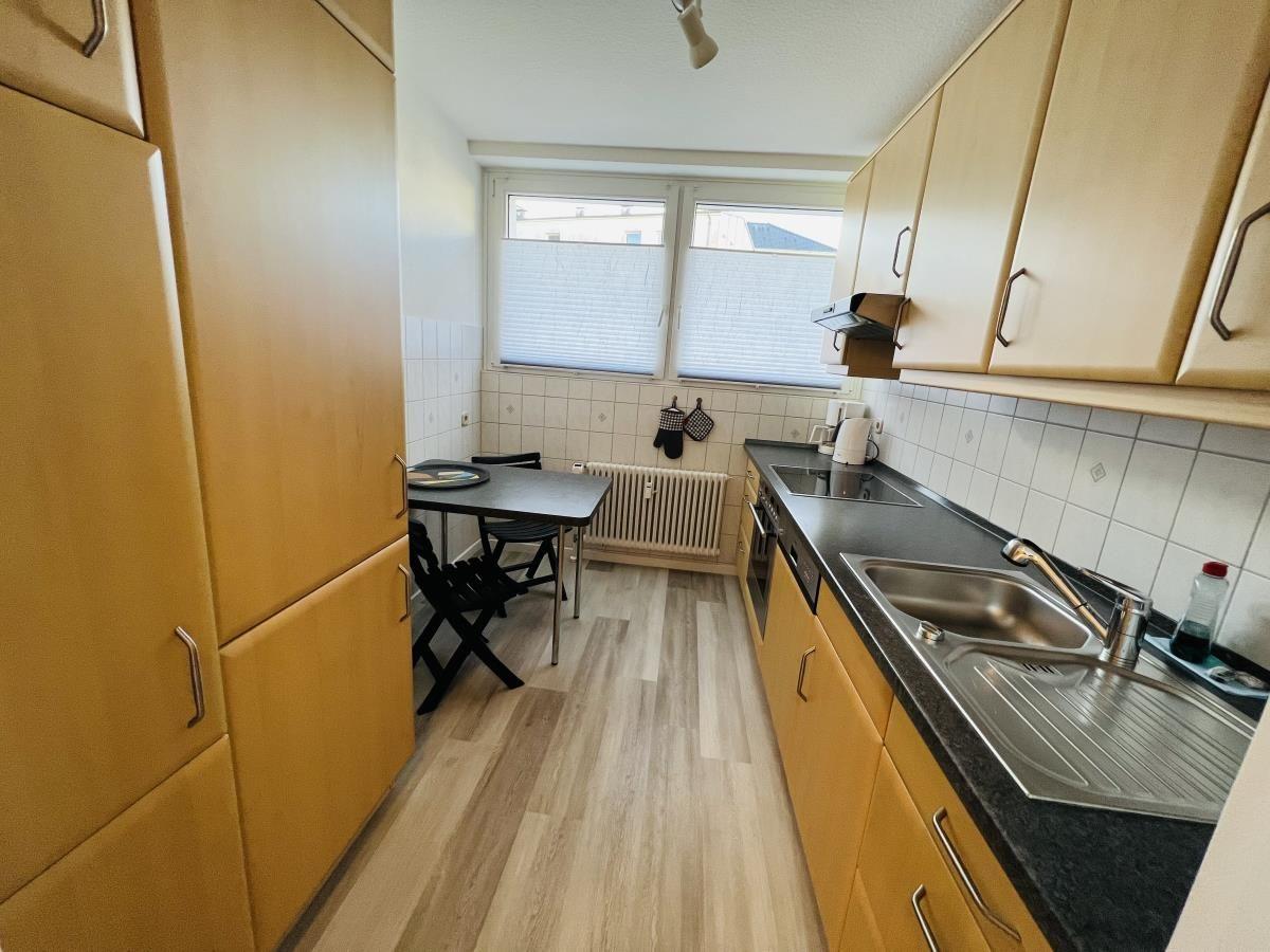 Küche mit Arbeitsfläche, Spüle und Essplatz.