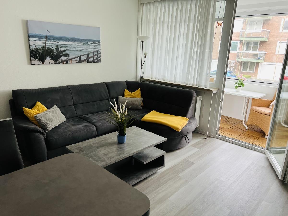 Wohnzimmer mit Sofa, Couchtisch und Balkonansicht.