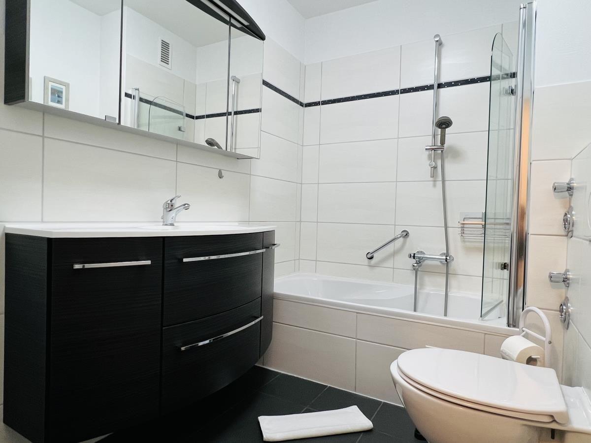 Badezimmer mit Dusche, Badewanne und Waschbecken