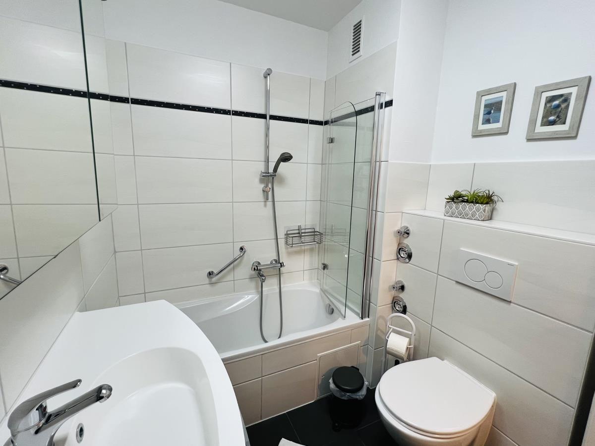 Badezimmer mit Badewanne, Dusche, Waschbecken und WC.