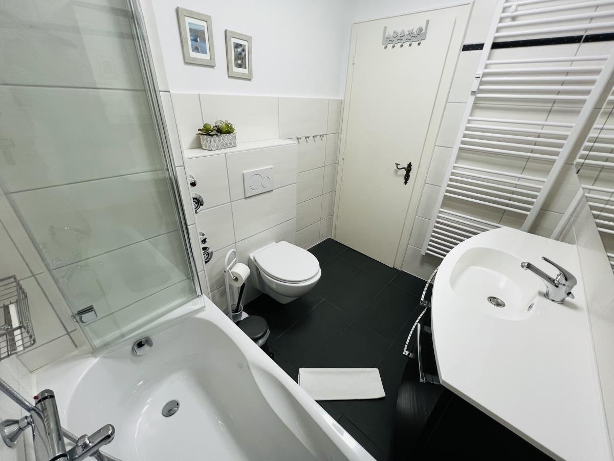 Badezimmer mit Badewanne, Dusche, Waschbecken und Toilette.