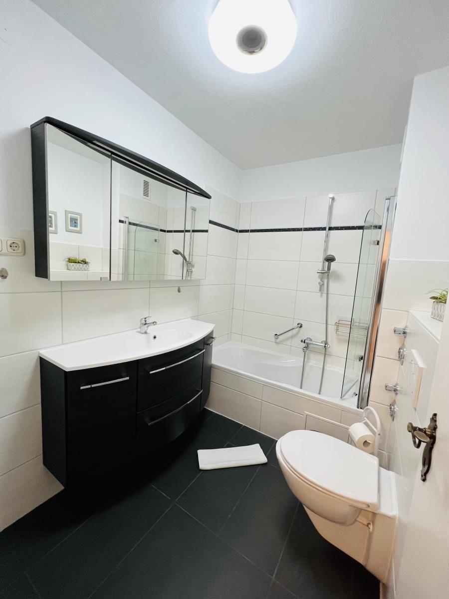 Badezimmer mit Badewanne, Dusche, Waschbecken und Toilette.