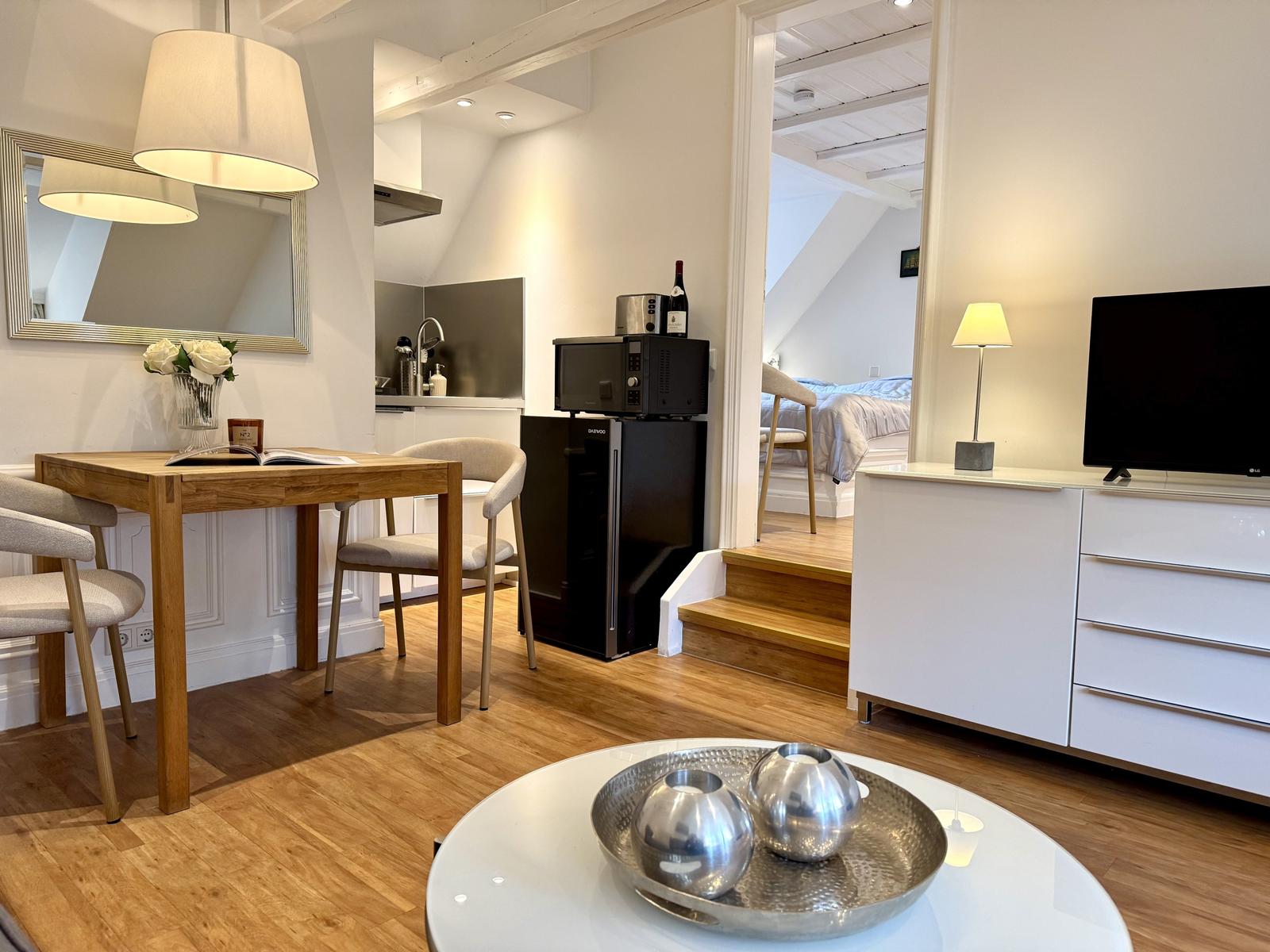 Wohnung mit Essbereich, Küche und TV. Treppen zur Schlafzimmer.