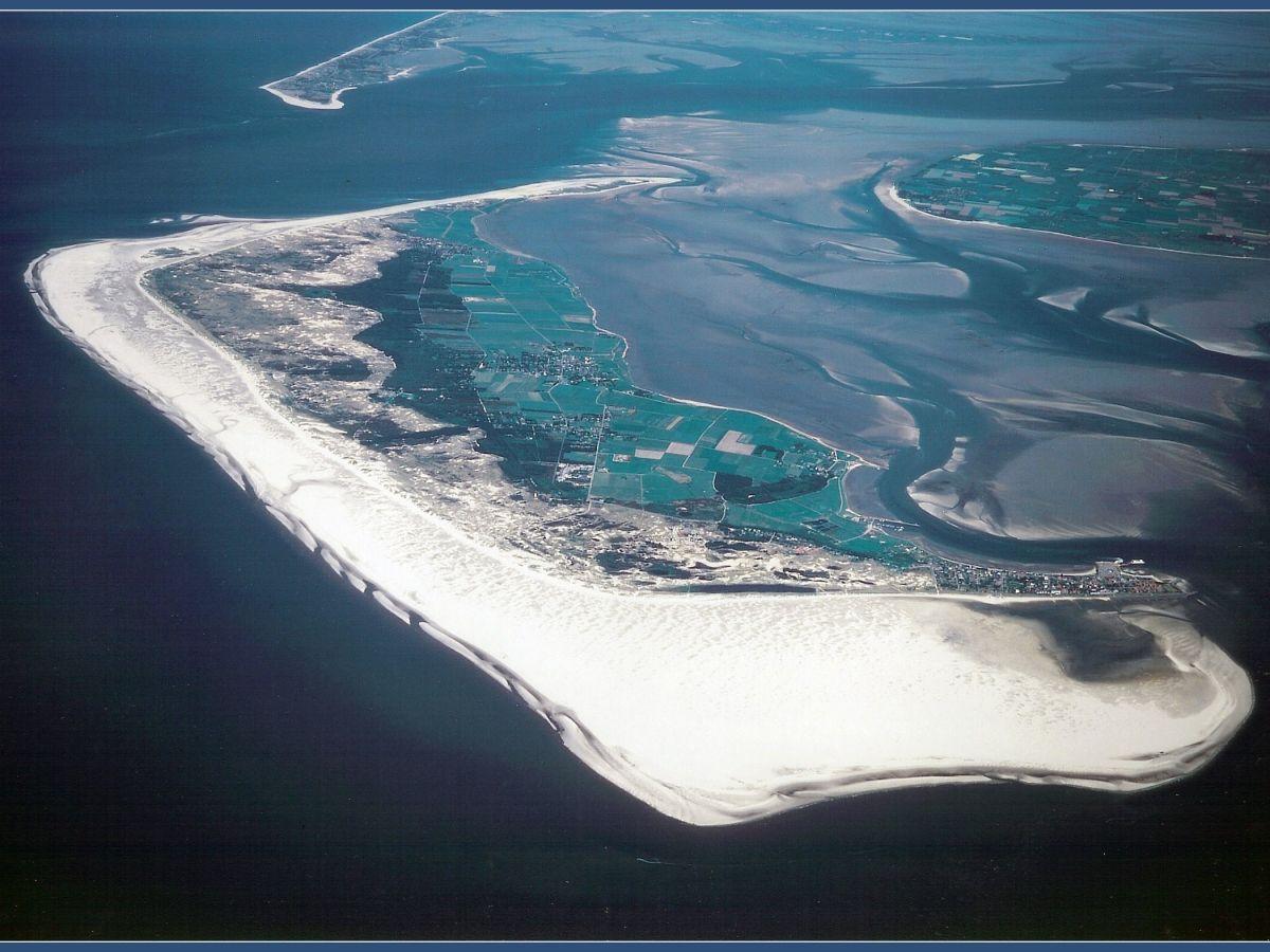 Aerial view of a coastal island with fields and sandy shores.