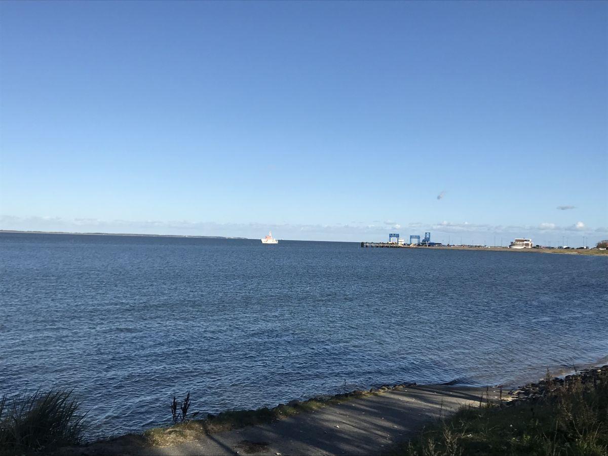 Meeresblick mit Schiff und Hafen im Hintergrund